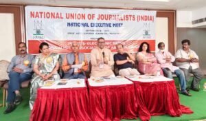National Union of Journalists (India) holds Vijayawada meet; calls for constitutional clarity on media freedom, highlights challenges to press access, and stresses mission-driven, responsible journalism.  Vijayawada, Andhra Pradesh: NUJ(I) president Suresh Sharma has urged the Central Government to amend Article 19(1)(A) of the Constitution to define media’s freedom of expression separately from that of individuals. Speaking at the national executive committee meeting of the National Union of Journalists (India) in Vijayawada, Sharma said that while freedom of expression is a fundamental right for citizens, media has a distinct role in amplifying the voices of others. Unless this distinction is recognized in law, he argued, the very idea of press freedom will remain incomplete.  Sharma strongly criticized the practice of restricting journalists’ entry into central and state secretariats, calling it a violation of democratic traditions. He reminded that leaders from Pandit Nehru to Atal Bihari Vajpayee had been staunch defenders of press freedom, and today’s restrictions weaken both democracy and journalism.  NUJ(I) General Secretary Triyug Narayan Tiwari echoed the call, stressing that journalism must once again become a mission. “Democracy needs real journalism today. The task is not merely to attract attention to issues, but to take people’s problems to government and administration and seek solutions,” he said. Tiwari expressed concern that in several states, reporters are harassed with cases of “obstruction of government work” whenever they expose corruption or misuse of power.  A key resolution was passed at the meeting, originally presented by senior journalist Umesh Chaturvedi and supported by Bihar journalist Rakesh Praveer. After an open debate and intervention from UP unit president Sarvesh Kumar Singh, the proposal was adopted, despite initial opposition from some delegates. The resolution called for explicitly defining media’s freedom of expression as distinct from individual freedom under Article 19(1)(A).  The conference also discussed the growing difficulties faced by journalists in news gathering, pointing out that even the Right to Information Act has lost much of its effectiveness in practice. Several other demands were raised, including the formation of a new wage board to revise pay scales, the creation of a Media Commission and Media Council, restoration of railway concessions, exemption from toll taxes, exclusion of the media sector from GST, and relief from restrictive RNI and DAVP circulars.  Special sessions focused on women journalists’ challenges. Abha Nigam, head of the women’s cell, pledged a nationwide campaign to promote safe and dignified working conditions, while Kavita Raj presented practical suggestions for addressing gender-specific concerns.  Former NUJ(I) president Ashok Malik emphasized strengthening the organization to protect journalists more effectively. Veteran journalist Rajeev Shukla advised patience and perseverance in the profession, while Ravindra Vajpeyi underlined the importance of inter-state news exchange to build a national perspective on press issues. Senior leader Sri Nageshwar Rao of NUJ(I) also participated in the deliberations, and Organizing Secretary Purushotham Naragouni was present along with other national office-bearers.  Adding significance to the occasion, Smt. Tella Kasturi, Regional Joint Director, Information and Public Relations Department, Government of Telangana, attended as the chief guest. In her address, she underlined the importance of freedom of the press and called for responsible journalism that strengthens democracy. She also felicitated journalists and participants, acknowledging their role in safeguarding public interest through ethical reporting.  The gathering reflected wide national participation. Odisha president Sri Kailash Naik, Baldev Sharma of Jharkhand, Secretary (South) Chandra Mohan, and TSJU General Secretary Anil Kumar joined the deliberations. In total, nearly 90 members of the NUJ(I) National Executive Committee attended, giving the event a truly nationwide character.  The meeting was hosted by PENJAP, a leading Andhra Pradesh journalists’ body affiliated with NUJ(I). National Vice-President and PENJAP President Bade Prabhakar and his team were thanked by delegates for their efforts in organizing the conference. Journalists from several states were felicitated, and distinguished guests were honored on stage.  In closing, General Secretary Tiwari thanked all participants, and President Sharma formally declared the session concluded. Delegates suggested that future meeting venues be announced well in advance, as new railway booking rules require reservations two months prior.  The Vijayawada session ended with a strong message: India’s democracy needs an empowered press, legal clarity on media freedom, and a renewed commitment to journalism as a mission for public good.