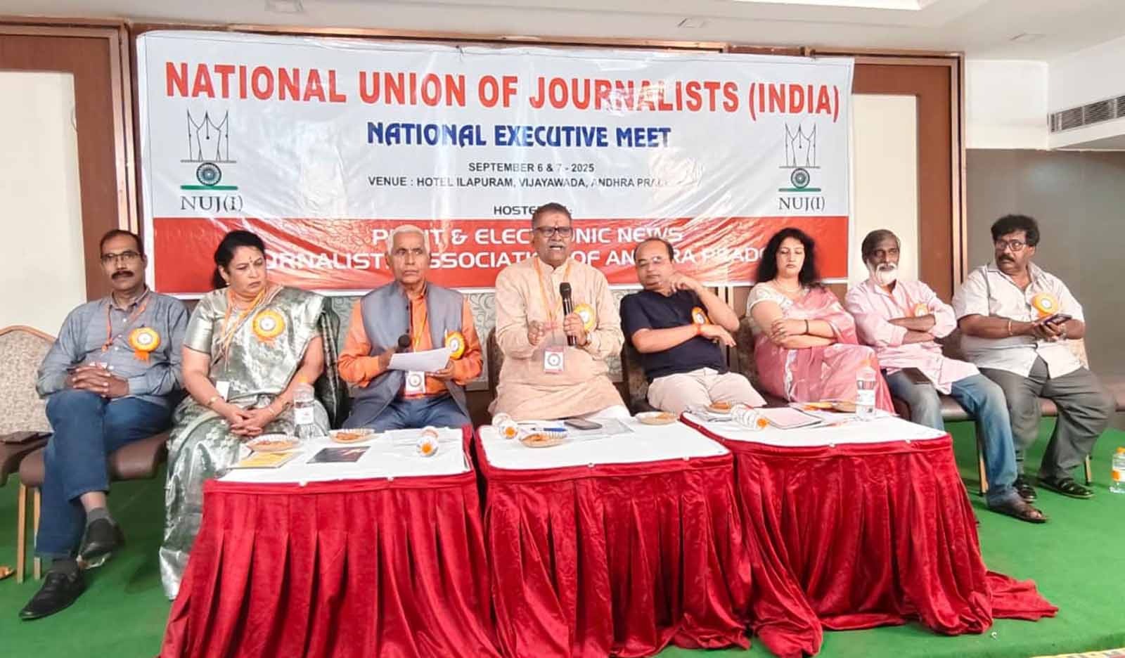 National Union of Journalists (India) holds Vijayawada meet; calls for constitutional clarity on media freedom, highlights challenges to press access, and stresses mission-driven, responsible journalism.  Vijayawada, Andhra Pradesh: NUJ(I) president Suresh Sharma has urged the Central Government to amend Article 19(1)(A) of the Constitution to define media’s freedom of expression separately from that of individuals. Speaking at the national executive committee meeting of the National Union of Journalists (India) in Vijayawada, Sharma said that while freedom of expression is a fundamental right for citizens, media has a distinct role in amplifying the voices of others. Unless this distinction is recognized in law, he argued, the very idea of press freedom will remain incomplete.  Sharma strongly criticized the practice of restricting journalists’ entry into central and state secretariats, calling it a violation of democratic traditions. He reminded that leaders from Pandit Nehru to Atal Bihari Vajpayee had been staunch defenders of press freedom, and today’s restrictions weaken both democracy and journalism.  NUJ(I) General Secretary Triyug Narayan Tiwari echoed the call, stressing that journalism must once again become a mission. “Democracy needs real journalism today. The task is not merely to attract attention to issues, but to take people’s problems to government and administration and seek solutions,” he said. Tiwari expressed concern that in several states, reporters are harassed with cases of “obstruction of government work” whenever they expose corruption or misuse of power.  A key resolution was passed at the meeting, originally presented by senior journalist Umesh Chaturvedi and supported by Bihar journalist Rakesh Praveer. After an open debate and intervention from UP unit president Sarvesh Kumar Singh, the proposal was adopted, despite initial opposition from some delegates. The resolution called for explicitly defining media’s freedom of expression as distinct from individual freedom under Article 19(1)(A).  The conference also discussed the growing difficulties faced by journalists in news gathering, pointing out that even the Right to Information Act has lost much of its effectiveness in practice. Several other demands were raised, including the formation of a new wage board to revise pay scales, the creation of a Media Commission and Media Council, restoration of railway concessions, exemption from toll taxes, exclusion of the media sector from GST, and relief from restrictive RNI and DAVP circulars.  Special sessions focused on women journalists’ challenges. Abha Nigam, head of the women’s cell, pledged a nationwide campaign to promote safe and dignified working conditions, while Kavita Raj presented practical suggestions for addressing gender-specific concerns.  Former NUJ(I) president Ashok Malik emphasized strengthening the organization to protect journalists more effectively. Veteran journalist Rajeev Shukla advised patience and perseverance in the profession, while Ravindra Vajpeyi underlined the importance of inter-state news exchange to build a national perspective on press issues. Senior leader Sri Nageshwar Rao of NUJ(I) also participated in the deliberations, and Organizing Secretary Purushotham Naragouni was present along with other national office-bearers.  Adding significance to the occasion, Smt. Tella Kasturi, Regional Joint Director, Information and Public Relations Department, Government of Telangana, attended as the chief guest. In her address, she underlined the importance of freedom of the press and called for responsible journalism that strengthens democracy. She also felicitated journalists and participants, acknowledging their role in safeguarding public interest through ethical reporting.  The gathering reflected wide national participation. Odisha president Sri Kailash Naik, Baldev Sharma of Jharkhand, Secretary (South) Chandra Mohan, and TSJU General Secretary Anil Kumar joined the deliberations. In total, nearly 90 members of the NUJ(I) National Executive Committee attended, giving the event a truly nationwide character.  The meeting was hosted by PENJAP, a leading Andhra Pradesh journalists’ body affiliated with NUJ(I). National Vice-President and PENJAP President Bade Prabhakar and his team were thanked by delegates for their efforts in organizing the conference. Journalists from several states were felicitated, and distinguished guests were honored on stage.  In closing, General Secretary Tiwari thanked all participants, and President Sharma formally declared the session concluded. Delegates suggested that future meeting venues be announced well in advance, as new railway booking rules require reservations two months prior.  The Vijayawada session ended with a strong message: India’s democracy needs an empowered press, legal clarity on media freedom, and a renewed commitment to journalism as a mission for public good.